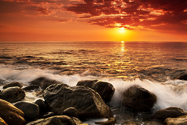 A sunset over a rocky beach
