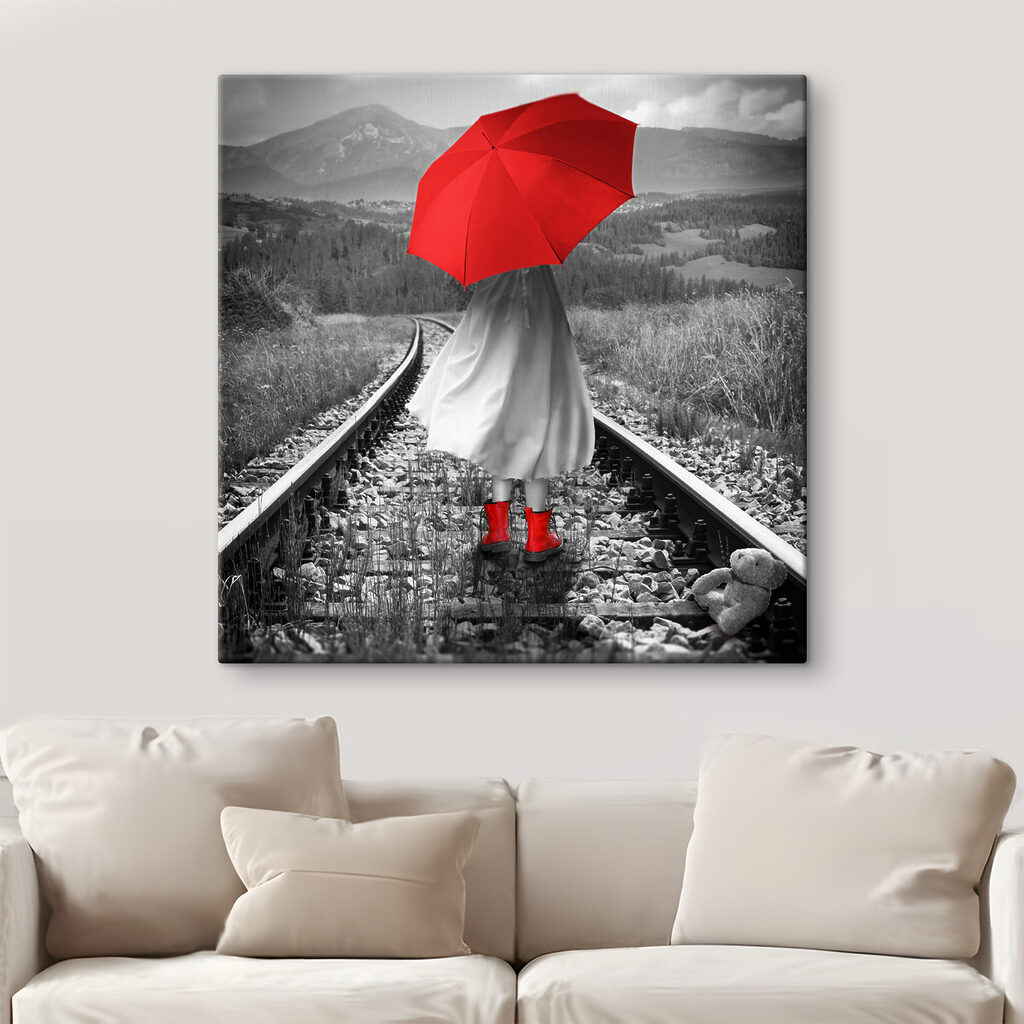 A person with a red umbrella on a train track A person with a red umbrella on a train track