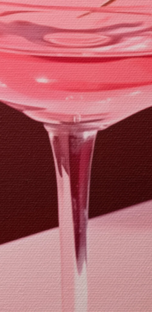Glass with pink liquid and two cherries on it