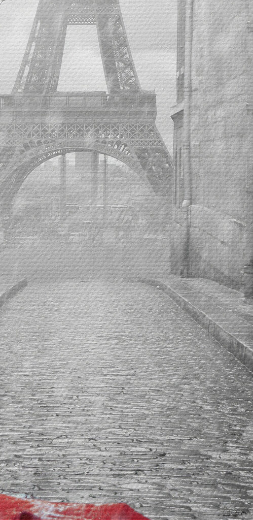 A red umbrella in a street with a tower in the background A red umbrella in a street with a tower in the background